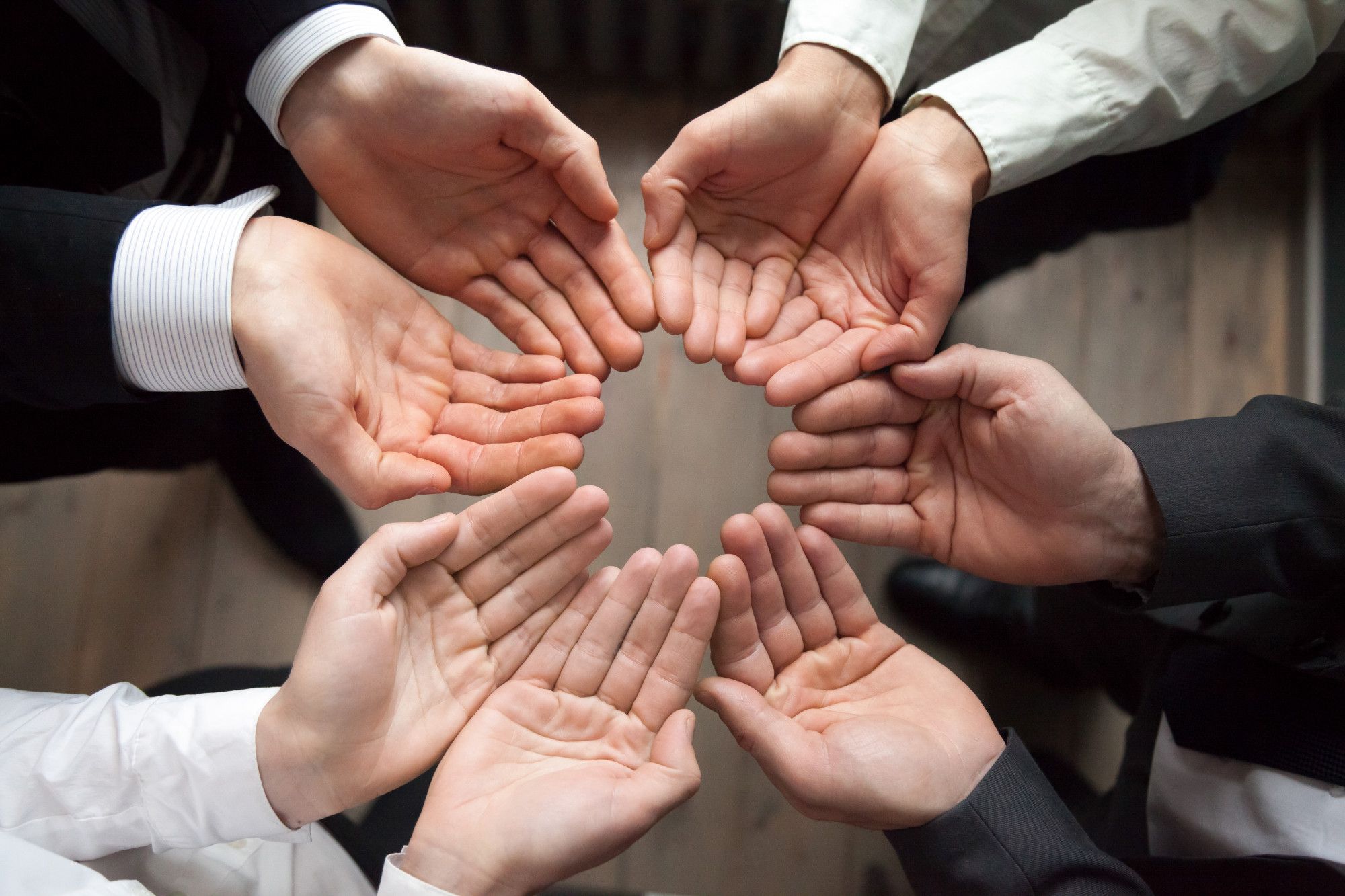 Hands forming a circle symbolizing collaboration.