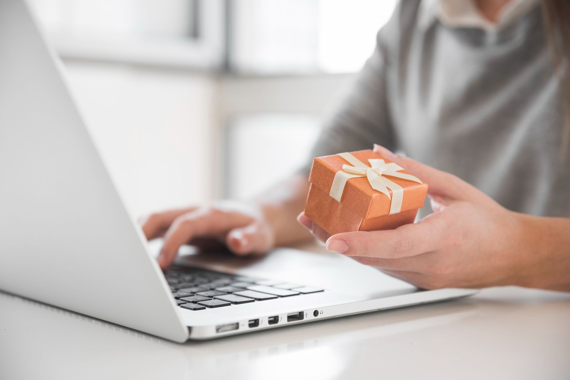 User holding a small gift while accessing a digital loyalty platform.